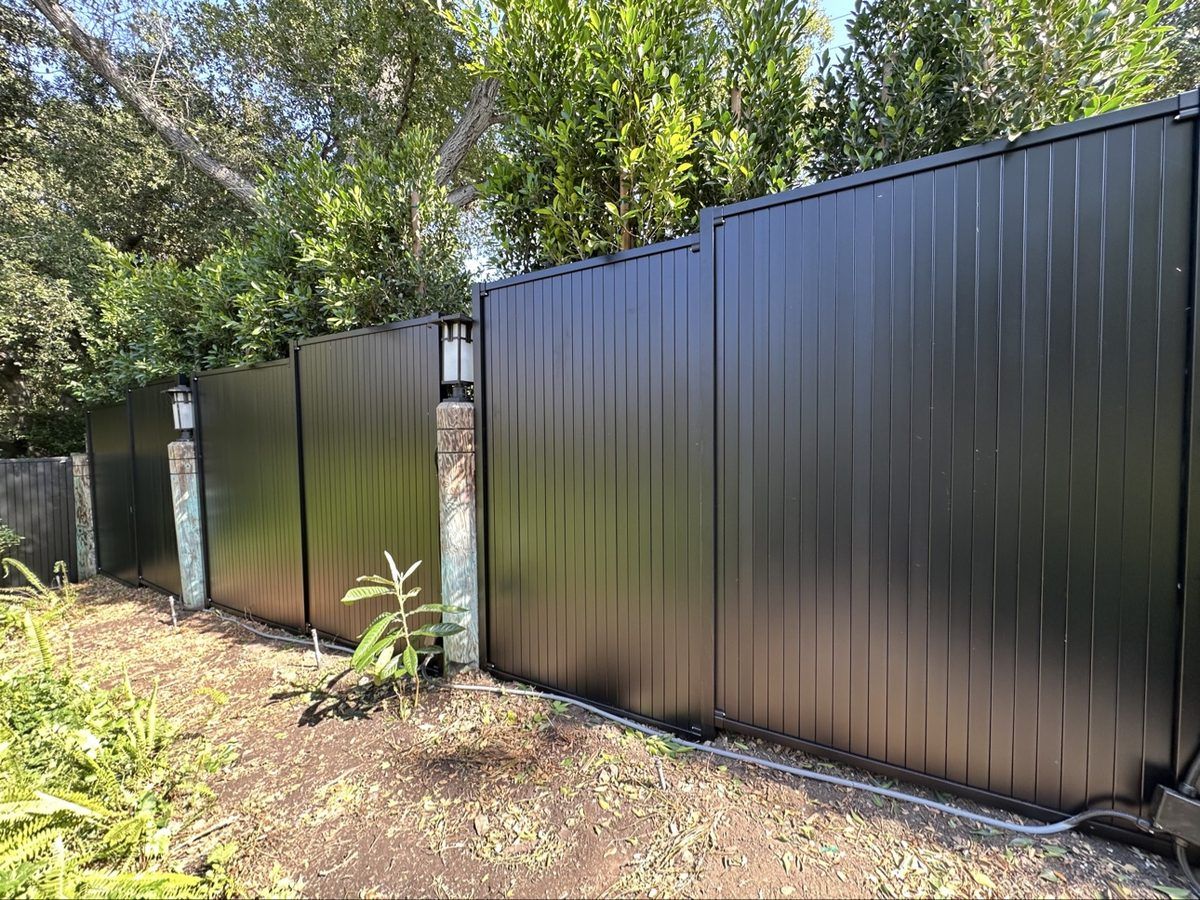 Black aluminum privacy fence with stone pillars installed in Los Angeles by Customize Vinyl Fencing
