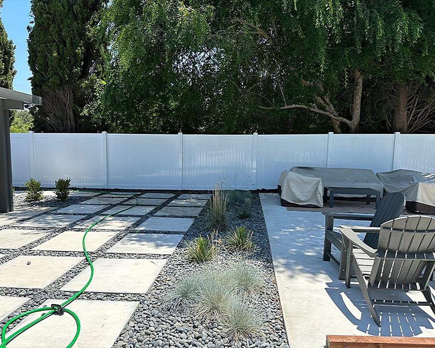 White vinyl privacy fence in a landscaped backyard
