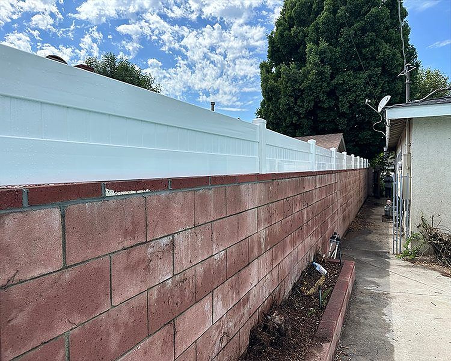 White vinyl fence topper on a brick wall