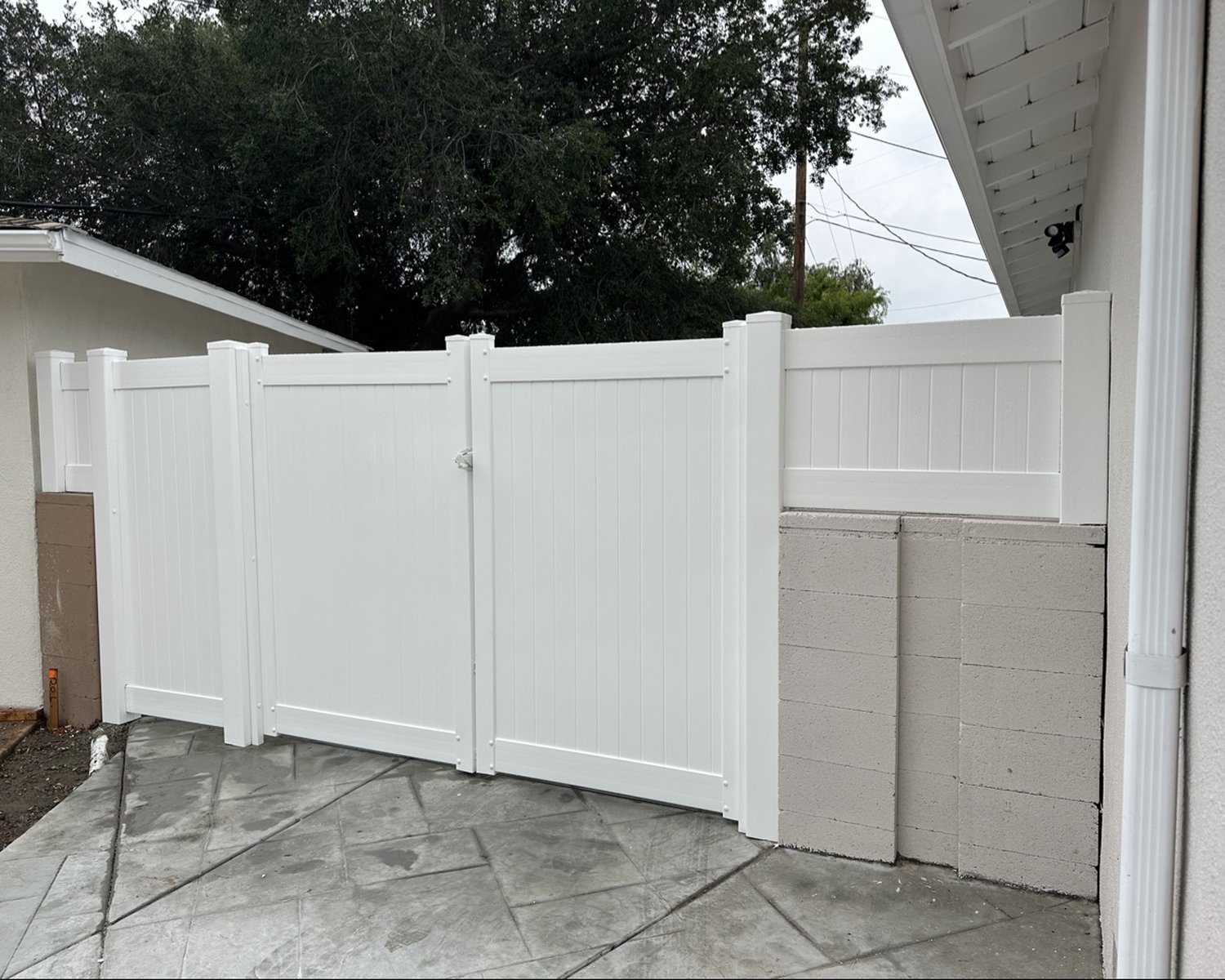 White vinyl double gate on a block wall