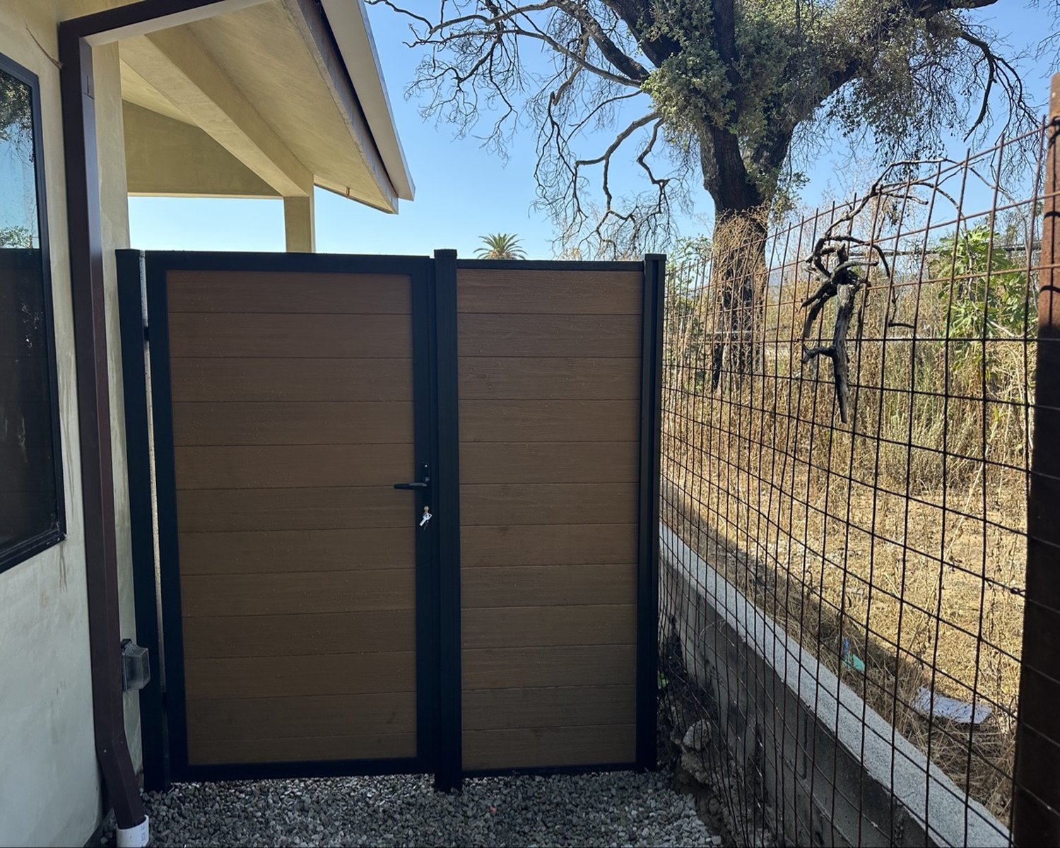 Wood-look vinyl gate with black aluminum frame