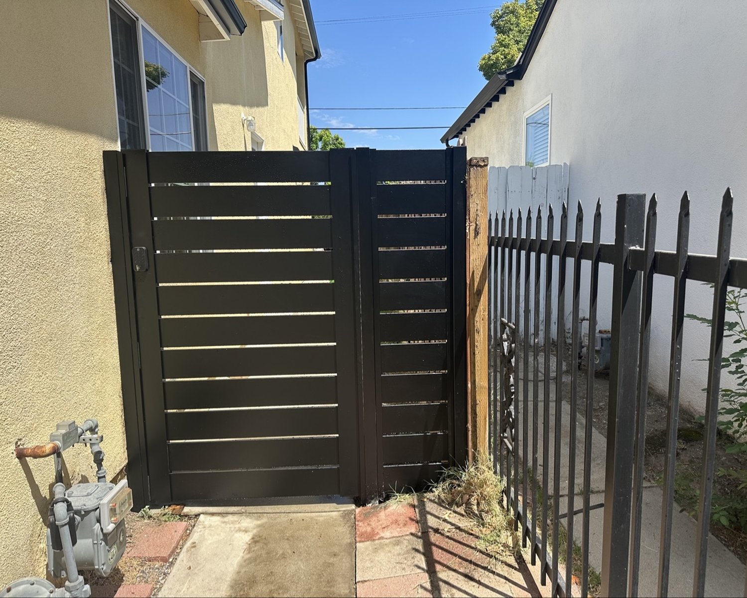 Black horizontal-slat side gate with lock