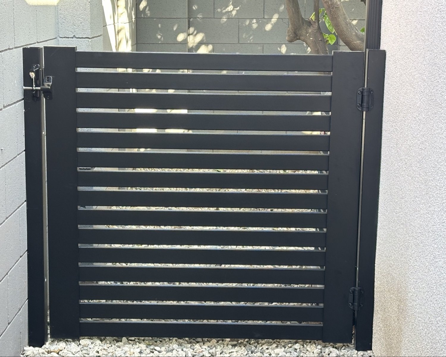 Black horizontal-slat gate with latch and deadbolt