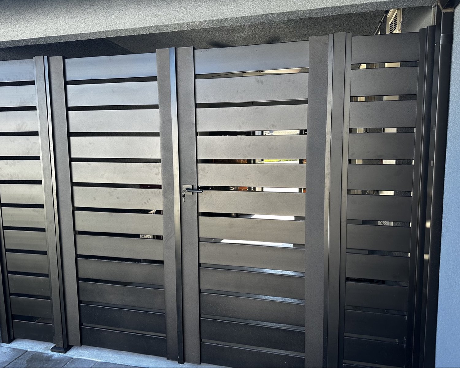 Close view of black horizontal-slat double gate