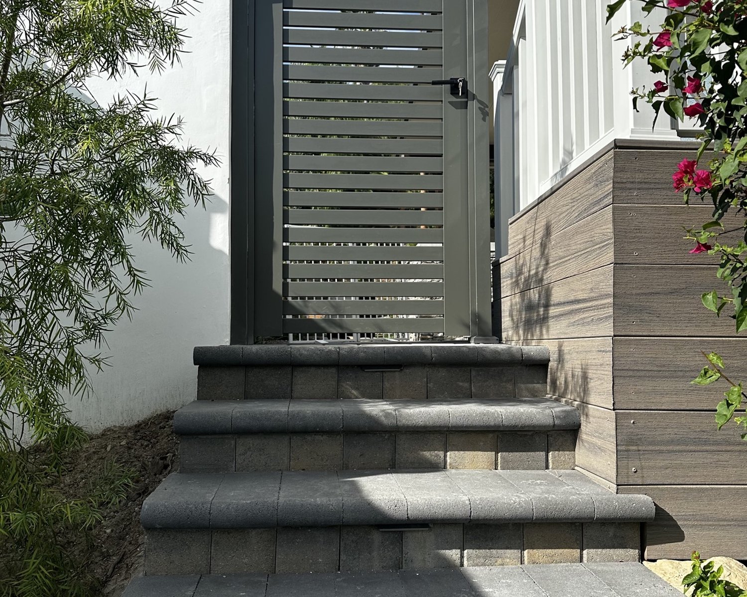 Gray horizontal-slat gate above entry steps