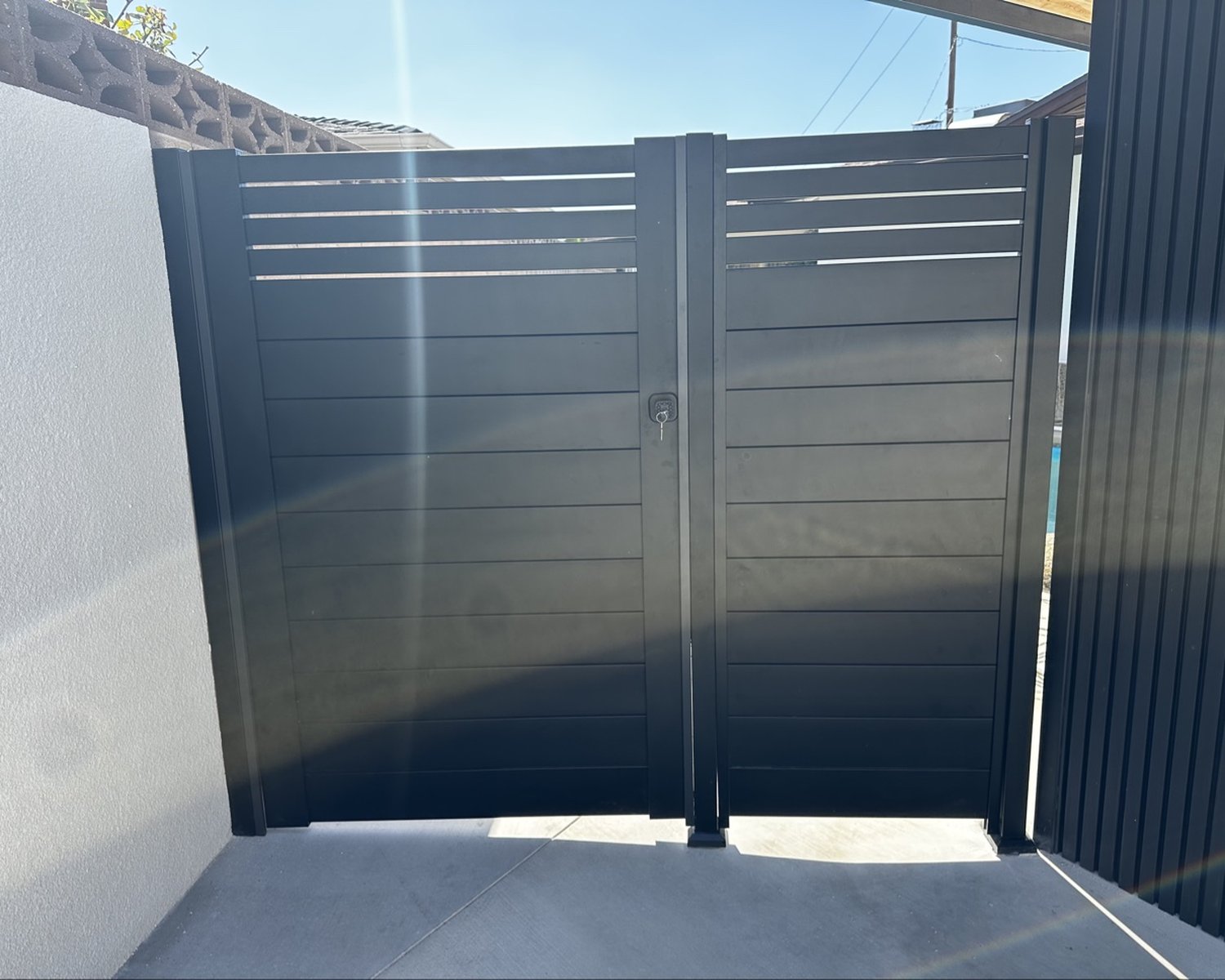 Black horizontal-slat double gate with keypad lock