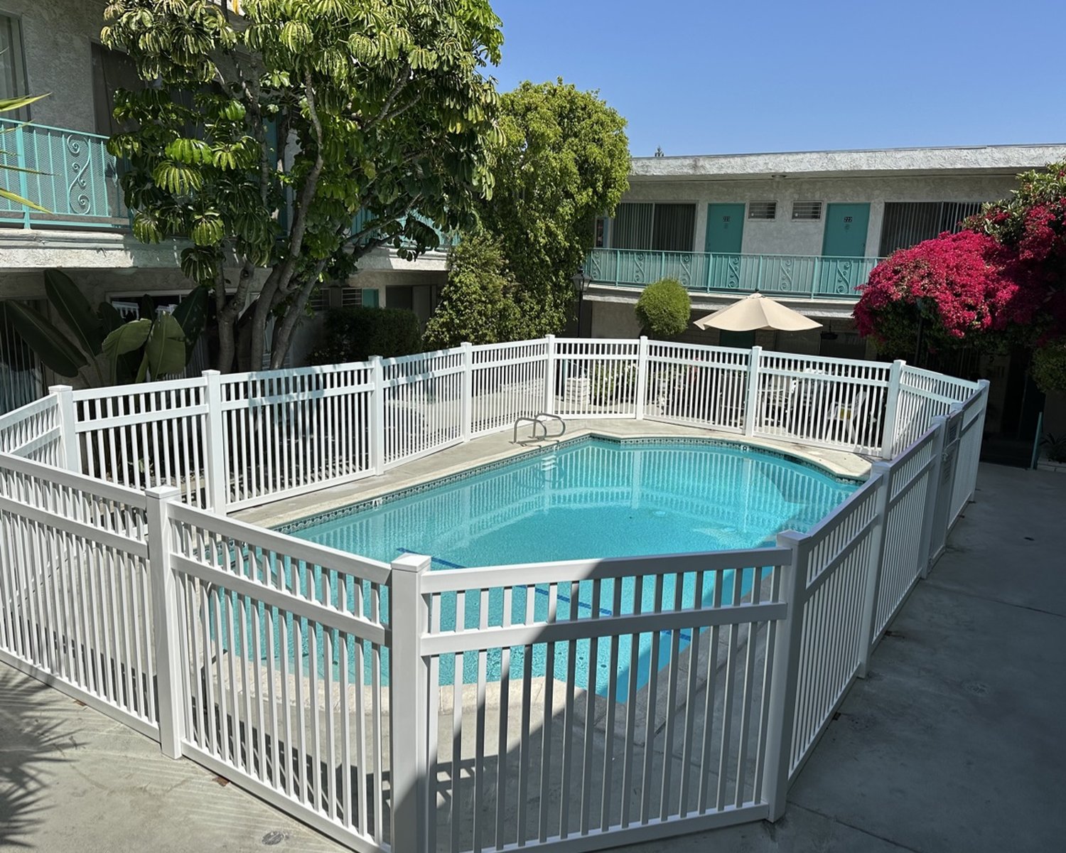 White vinyl pool railing around a community pool